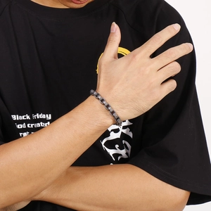 Gros plan d'un bracelet gourmette en métal gris anthracite au style industriel et rétro chic