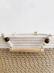 Handwoven beige cotton rope tote bag with wooden handles and decorative beads