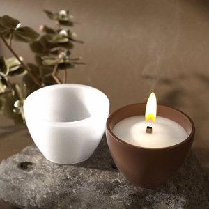 Detailed close-up of handmade round resin candle cup mold with wooden wick and flame