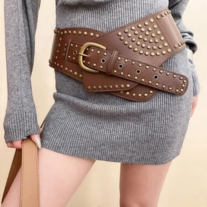 Detailed view of a brown punk leather waist belt with gold studs and a large metal buckle