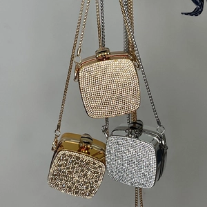 Close-up of sparkling rhinestone evening mini bags in gold and silver with chain straps