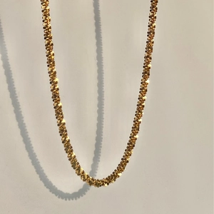 Elegant 18k gold plated stainless steel star chain necklace shown against a grey wall