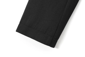 Gros plan sur les coutures et la texture du tissu noir de la robe avec fente