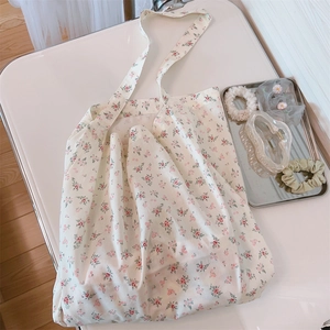 Primer plano detallado del bolso de algodón suave con un delicado diseño floral rosa