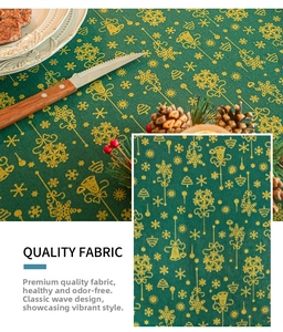 Detail of green Christmas tablecloth with gold snowflake bells and wavy edge design