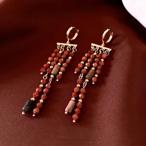 Boucles d'oreilles créoles dorées vintage avec perles brunes et glands sur soie rouge