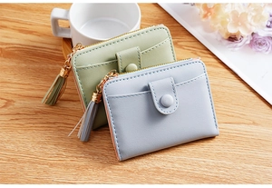 Detail of PU leather wallets with snap closure, tassels, and smooth pebble texture