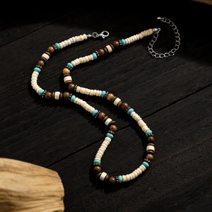 Bohemian surfing necklace with turquoise and wood beads on a dark wooden table