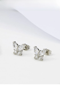 Macro detail of butterfly stud earrings featuring cubic zirconia and silver plating