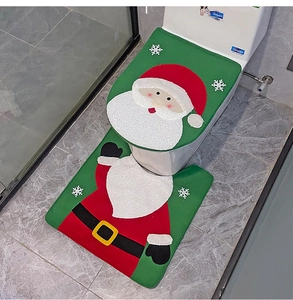 Detail of Christmas Santa toilet cover set with red and green plush bathroom mats