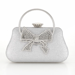 Close-up of glitter evening bag featuring a rhinestone bow and metal ring handle