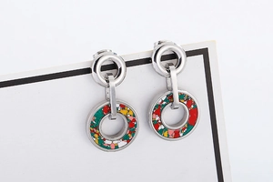 Macro detail of silver circle earrings with colorful mosaic resin and stone inlay