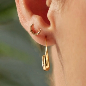 Detail of 14K gold plated stainless steel triple-layer C-shape hoop earring on ear