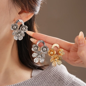 Detailed shot of gold and silver layered flower earrings with hammer-textured metal finish