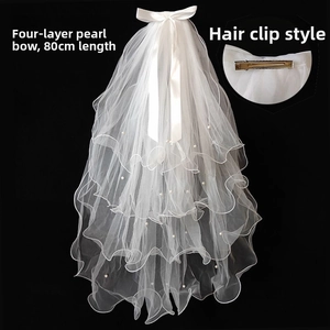 Detail of 80cm four-layer white tulle bridal veil with pearls, satin bow, and hair clip