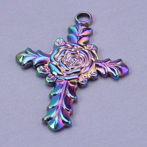 Macro detail of iridescent stainless steel cross pendant with carved rose and leaves