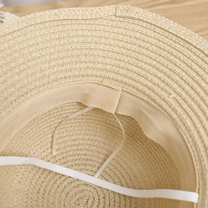 Detail view of the straw sun hat interior showing sweatband and elastic chin strap