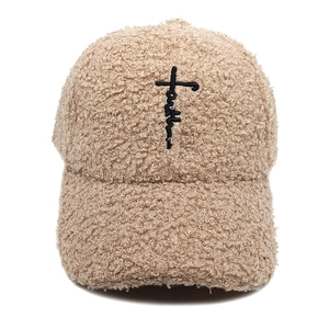 Détail de la broderie croix avec lettrage faith sur casquette en polaire beige