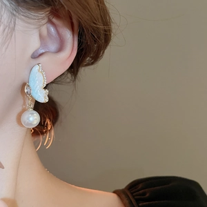 Elegant butterfly pearl earrings with gold-plated hook shown on model side profile view
