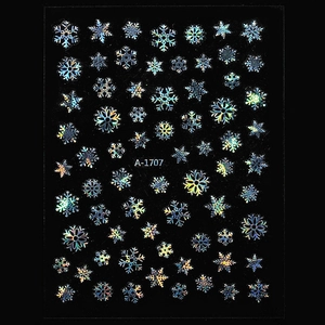 Detailed macro view of laser holographic snowflake nail art stickers on a black background