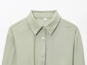 Detail view of the light green linen shirt collar and neat stitching in size S
