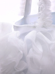 Detail of layered white lace ruffles and mesh fabric texture on a sweet style handbag