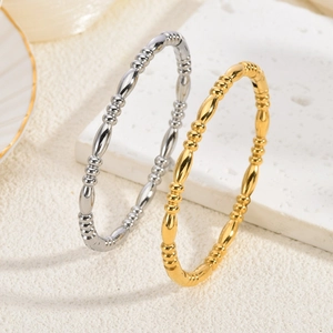 Polierte 18K Gold- und Silberarmbänder aus Edelstahl auf einem Marmordisplay
