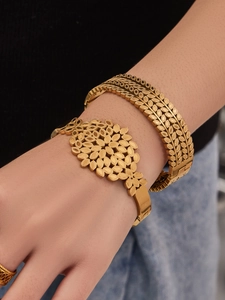 Close-up of dual-layer 18k gold plated bracelets with hollow geometric and leaf textures