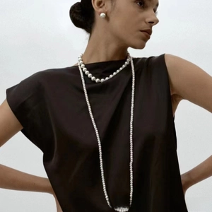 Détail d'un collier de perles multicouches élégant et boucles d'oreilles assorties