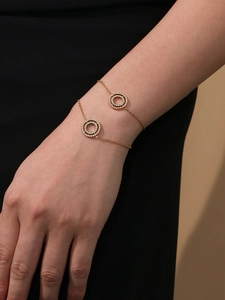 Detailed view of a gold double-circle bracelet with sparkling 5A cubic zirconia on a wrist
