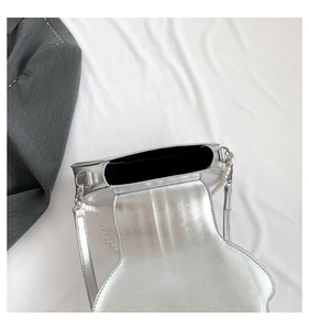 Detail der silbernen Muscheltasche mit schwarzem Innenfutter und eleganter Perlenkette