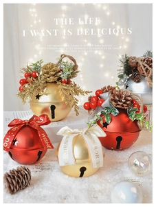 Macro shot of festive Christmas bells with pine cones and ribbon on a snow base