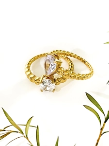 Detail of two-piece 18K gold plated ring set with pear and round shaped zircons