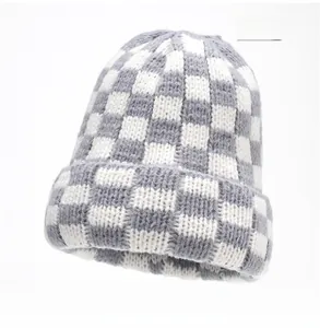 Detail of grey and white checkerboard knit beanie with thick fold-over cuff design