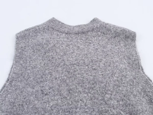 Dettaglio dello scollo del gilet grigio in maglia con trama di lana morbida e fine