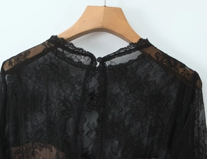 Détail du col montant en dentelle noire transparente avec crochet floral et bouton unique