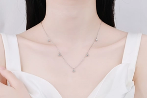 Detail of silver S925 sterling silver bubble necklace with five round moissanite pendants