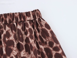Detail of the elastic waistband on leopard print trousers with soft fabric texture