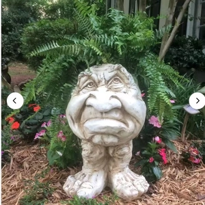 Funny Muggly face planter statue in weathered stone finish with garden greenery
