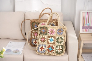 Close-up of handmade crochet granny square beach bag with floral patterns and round handle