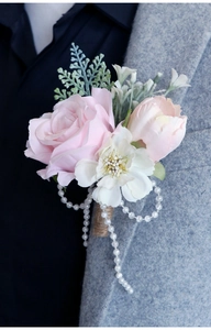 Detail of pink rose boutonniere with pearls and twine on a groom's grey coat