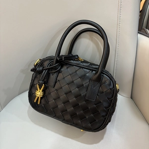 Chic black woven leather pillow handbag with gold hardware and stylish knotted handle