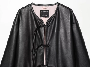 Detail of black leather jacket with Chinese frog button and pink satin lining