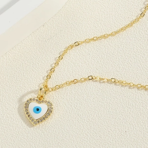 Close-up of heart-shaped evil eye pendant with blue enamel and sparkling crystals