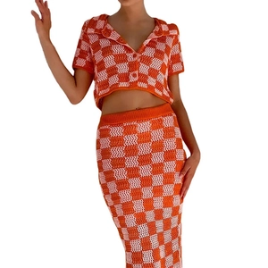 Dettaglio del set in maglia a scacchi arancione e bianco con top a bottoni e gonna longuette