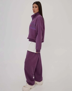 Detail of purple half-zip hoodie with artistic print and matching high waist joggers