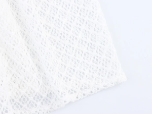 Macro shot of white mesh fabric detail with delicate diamond grid texture for summer dress