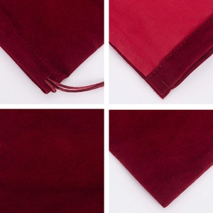 Detail view of red velvet drawstring pouch showing stitching, lining, and fabric texture