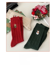 Detail of Christmas crew socks with snowman and reindeer embroidery in festive colors