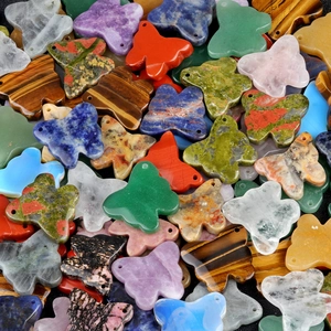 Assorted natural crystal butterfly pendants including amethyst, tiger eye, and rose quartz